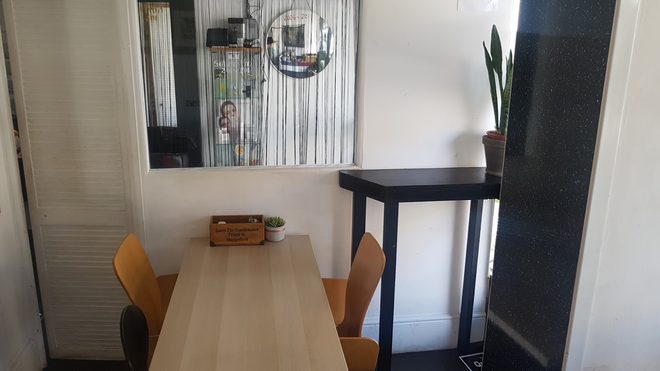The communal wooden table and chairs in the seating area